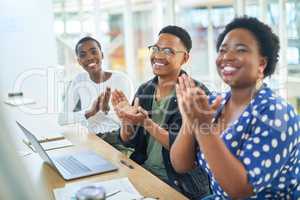The most productive meetings leave everyone feeling motivated. a group of businesspeople clapping during a meeting in a modern office.
