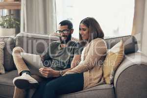 Whats better than a wifi connection The human one. a young couple using a laptop on the sofa at home.