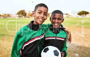 Growing up to become football sensations. Portrait of two young boys playing soccer on a sports field.