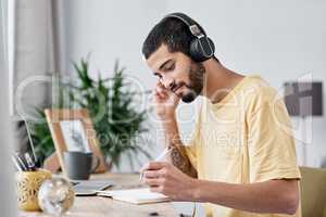 No noise, no problem. a young man using a laptop and headphones while working from home.