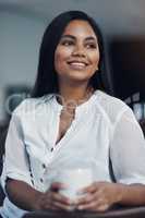 Taking a breather before getting back to her plans for success. a young businesswoman drinking coffee while taking a break in an office.