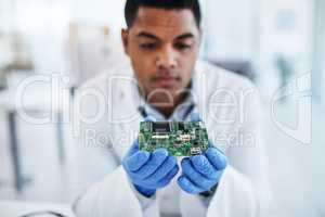 Nothing stays broken for long in his expert hands. a young man repairing computer hardware in a laboratory.