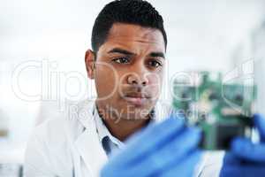 The electronic wizard hard at work. a young man repairing computer hardware in a laboratory.