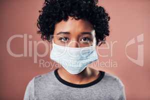 Wear a mask, stop the spread. Studio shot of a young wman wearing a mask against a pink background.