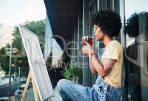 Those tangled thoughts are waiting to be untangled on the canvas. a young artist having tea while sitting on the balcony with a canvas.