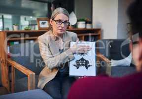 Time to change the way you look at life. a mature psychologist conducting an inkblot test with her patient during a therapeutic session.