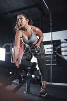 Building a stronger and fiercer version of herself. a sporty young woman exercising with a kettlebell in a gym.