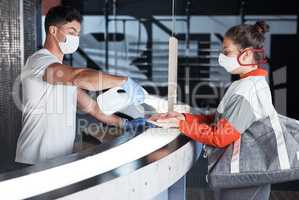 Following strict safety measures. a young woman receiving hand sanitiser from a staff member in a gym.