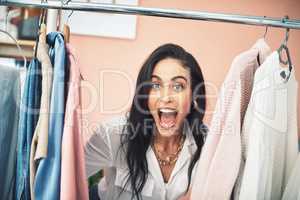 Today Im letting my followers into my wardrobe. a young woman sticking her head in between items on a clothing rail.