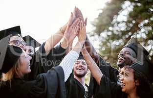 Believe and you will achieve. a group of students giving each other a high five on graduation day.
