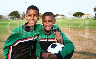 Were best buddies and teammates. Portrait of two young boys playing soccer on a sports field.