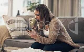 Extend the lifespan of your paycheque with smart financial planning. a young woman having coffee and using a smartphone while going through paperwork at home.