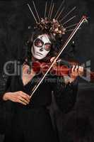 Halloween mood music. Cropped portrait of an attractive young woman dressed in her Mexican-style halloween costume playing a violin.