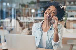 It feels good when your hard work starts to pay off. a businesswoman talking on her cellphone while working from a cafe.