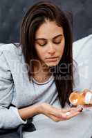 Take care, flu season is here. a young woman taking medication while recovering from an illness in bed at home.