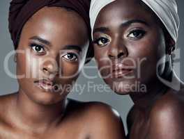 Were proud of our cultural background. Studio portrait of two beautiful young women posing against a grey background.