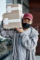 Keeping customers happy at a safe distance. a masked young man delivering a package to a place of residence.
