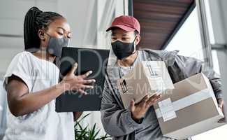 As efficient as a delivery service gets. a masked young woman signing for a delivery received at home.