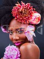 Flowers make everything better. Studio shot of a beautiful young woman posing with flowers in her hair.