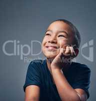 Imagine where your imagination could take you. Studio shot of a cute little boy looking thoughtful against a grey background.