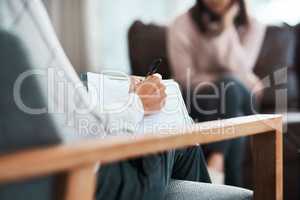 Every point is a piece of her story. a psychologist writing notes during a therapeutic session with her patient.