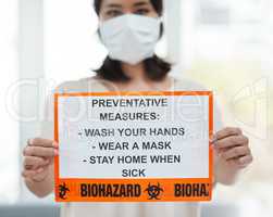 Follow these simple precautions to reduce your chances of getting infected. a woman holding up a sign with a list of COVID-19 prevention measures.