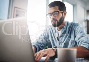 A good connection is all you need to work from home. a young man using his laptop while working from home.