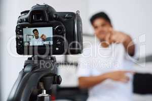 Ill be back tomorrow with a new video. a young man using a camera on a tripod to record himself at home.