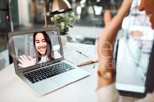 Digital collaborations done with ease across departments and locations. a young woman waving while appearing on a laptop screen during a video call.