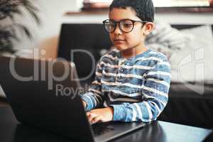 Growing up to become one smart kid. an adorable little boy using a laptop at home.
