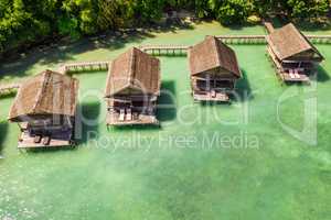 This truly is an island getaway. High angle shot of the overwater bungalows along the coast of the Raja Ampat Islands in Indonesia.