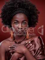 African Beauty personified. Cropped portrait of a beautiful young woman posing against a red background.