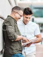 Great connectivity for those impromptu collaborations. two young businessmen using a digital tablet together against an urban background.