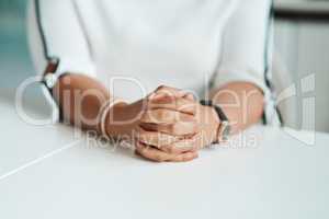 Waiting in anticipation for another great business opportunity. Closeup shot of an unrecognisable businesswoman sitting with her hands clasped in an office.