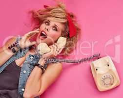 Its an emergency. Studio shot of a young woman holding a telephone while wearing 80s clothing.