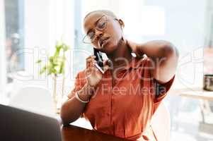 Experiencing work strain is unavoidable. a young businesswoman looking stressed out while talking on a cellphone in an office.