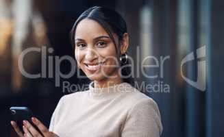 Communication is key. Cropped portrait of an attractive young businesswoman sending a text while working in her office.