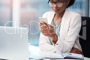 Business woman with a phone texting, browsing and searching social media while working in the office. Creative agent checking schedule list, multitasking and managing goals and tasks on technology