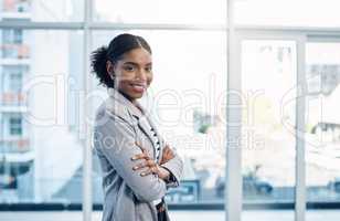 Confident, happy and ambitious woman with standing with her arms crossed and showing good leadership skills in a modern office. Portrait of a smiling business intern ready for a successful future