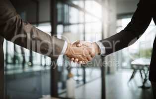 Professional corporate males giving handshake in modern office after agreeing on business deal closeup. Two confident, formal and executive men coming to an agreement together at the end of a meeting