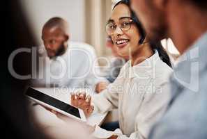 Give the task to us, well get it done. a young businesswoman using a digital tablet during a meeting in a modern office.