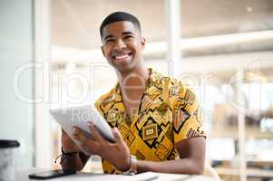 The prospects of success are looking positive for him. a young businessman using a digital tablet in an office.