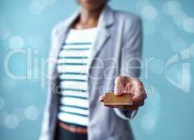 Credit card in the hands of a finance business woman paying, buying and making a purchase while standing against a blue studio background alone. Corporate professional giving a debit card for payment