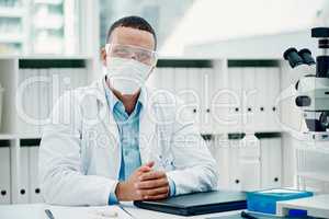 Cover up, your safety counts on it. Portrait of a young scientist using a laptop while working on a coronavirus cure in a laboratory.