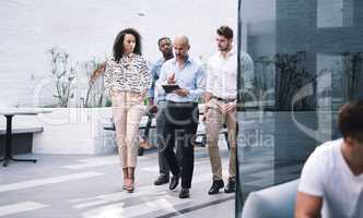 Every step forward is a step in the right direction. a group of businesspeople using a digital tablet while walking through a convention centre.