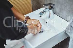 Step number one to staying healthy Put your hygiene first. an unrecognisable man washing his hands in the bathroom sink.