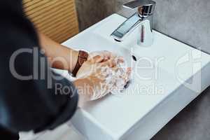 Hands down the best way to stay protected. an unrecognisable man washing his hands in the bathroom sink.