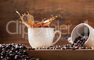 I like my coffee filled to the rim. a two cups against a wooden background filled with coffee and coffee beans.