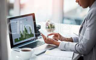 An accountant working on growth, tax review or expenses of a company with graphs or charts on a laptop screen. Closeup of a financial advisor typing on a phone while analyzing business statistics