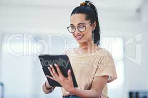 To stay relevant, you need to adapt to modern changes. a young designer using a digital tablet in an office.